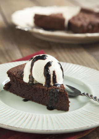 Piece of chocolate almond cornmeal cake with balsamic drizzle and ice cream  Selective focusの写真素材