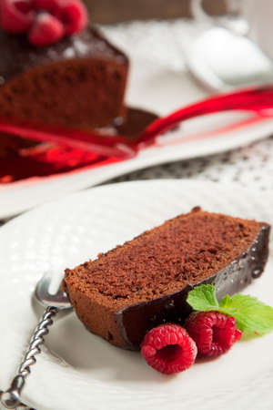 Chocolate loaf cake with chocolate frosting and raspberryの写真素材