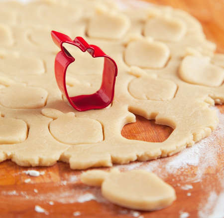 Apple shaped cookie cutter on raw cookie dough  Selective focusの写真素材