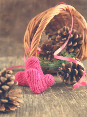 Pine cones and handmade crochet hearts in basketの写真素材