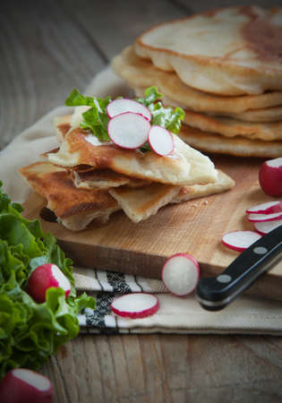 Homemade milk flatbread with cream cheese, lettuce and radishの写真素材