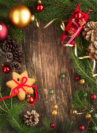 Frame with Christmas tree branches, cookies and ornaments on wooden backgroundの写真素材