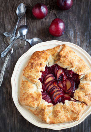 Fresh homemade plum galette on wooden tableの写真素材