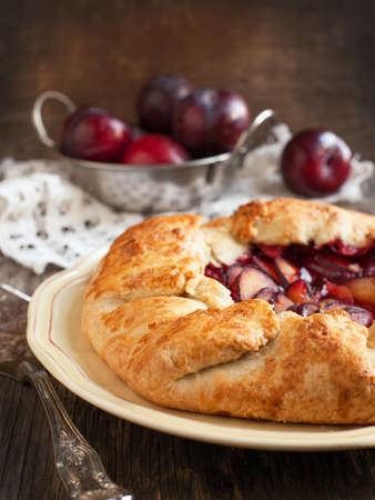 Fresh homemade plum galette on wooden tableの写真素材