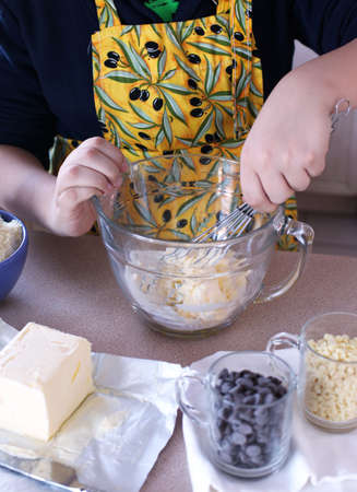 Boy, 12 years old, making a chocolate chips cookiesの写真素材
