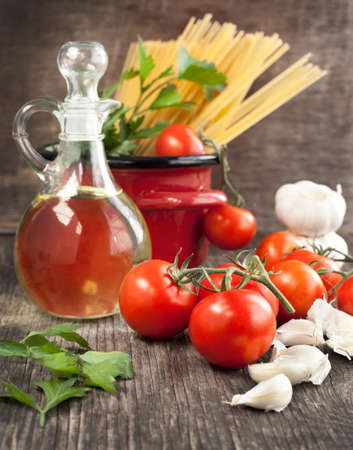 Italian Pasta with tomatoes, garlic, olive oil and italian parsley on wooden background  Toned imageの写真素材