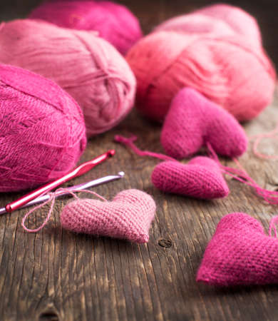 Crochet pink hearts  and yarn on wooden backgroundの写真素材