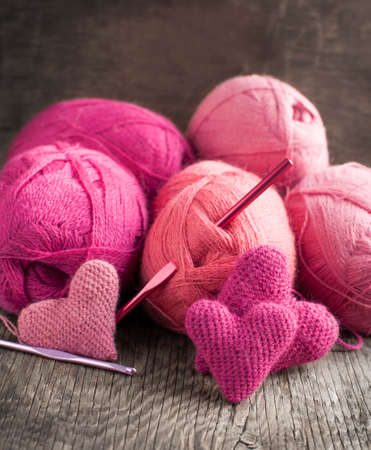 Crochet pink hearts  and yarn on wooden の写真素材