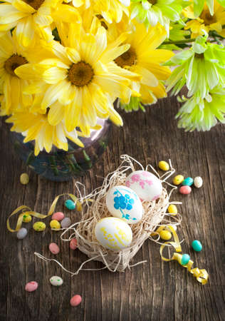 Still life with Easter eggs in basket and bouquet of flowersの写真素材