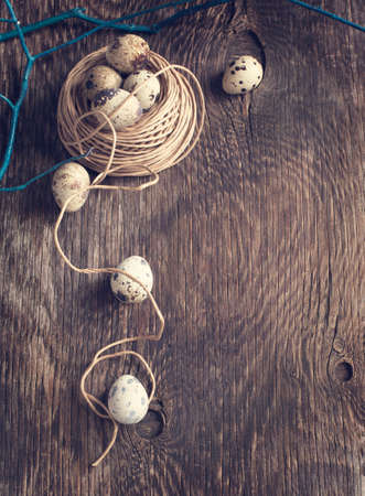 Easter decoration with quail eggs on wooden boardの写真素材