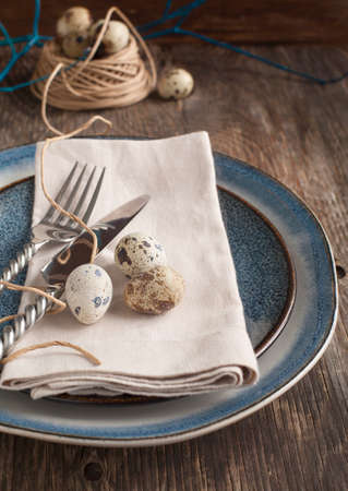 Easter table setting with quail eggs old wooden tableの写真素材