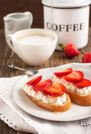 Fresh bread with Cottage cheese, strawberry and honeyの写真素材