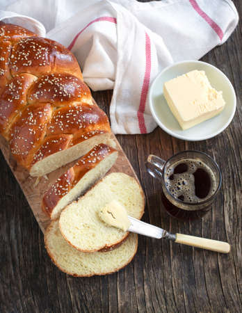 Freshly baked sweet braided bread loaf with butterの写真素材
