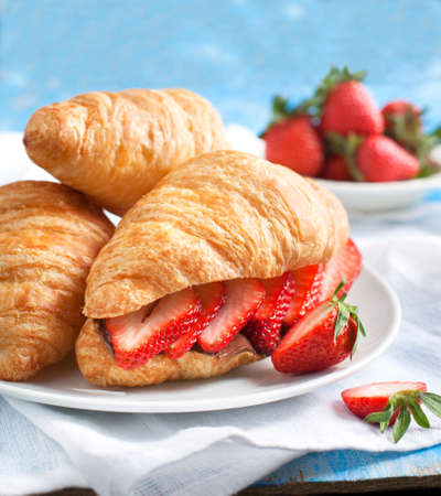 Fresh croissants with strawberry and chocolate nuts creamの写真素材
