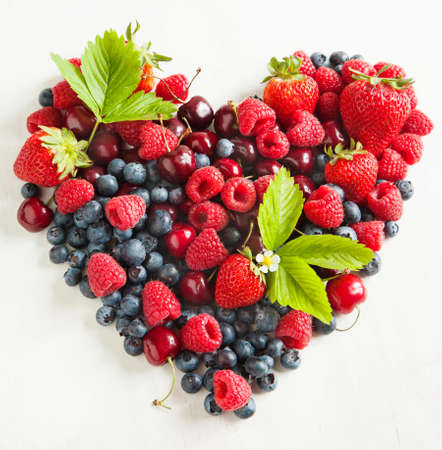 Assortment of summer fresh berries in the shape of heart の写真素材