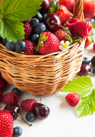 Assortment of summer fresh berries in the basketの写真素材