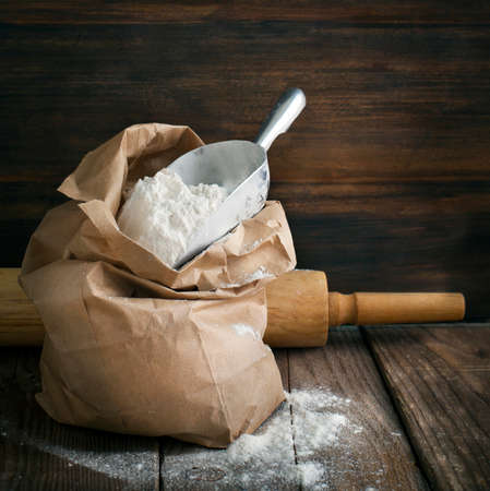 Flour in paper bag on wooden background.の写真素材