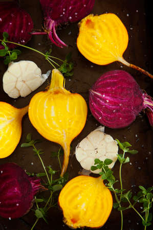Preparing raw beetroots and garlic for roasting on a baking trayの写真素材