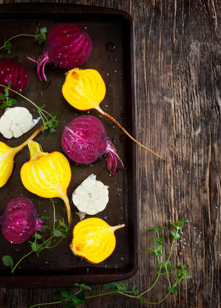 Preparing raw beetroots and garlic for roasting on a baking trayの写真素材