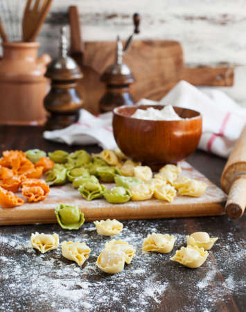 Uncooked tortellini with cheese on a tableの写真素材