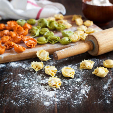 Uncooked tortellini with cheese on a tableの写真素材
