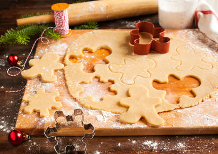 Making gingerbread cookies. Christmas baking background dough and cookie cutters.