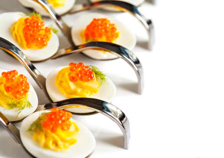 Deviled eggs with red caviar in a spoonの写真素材