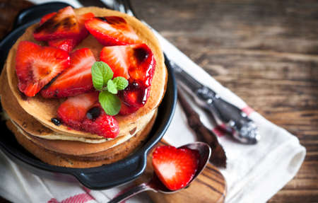 Stack of pancakes with fresh strawberry and balsamic glase in frying panの写真素材