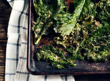 Crispy cheese and chili kale chips on baking trayの写真素材