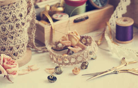 Tools for needlework thread for sewing scissors buttons and vintage laces . Toned imageの写真素材
