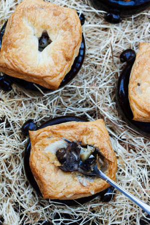 Mushroom, chicken and potato soup in pot with a lid of puff pastryの写真素材