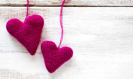 Crochet pink hearts on wooden backgroundの写真素材