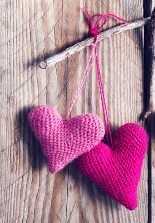 Crochet pink hearts on wooden backgroundの写真素材