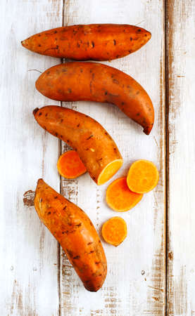 Raw sweet potatoes on wooden backgroundの写真素材