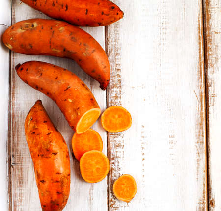 Raw sweet potatoes on wooden backgroundの写真素材