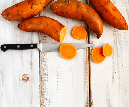 Raw sweet potatoes on wooden backgroundの写真素材