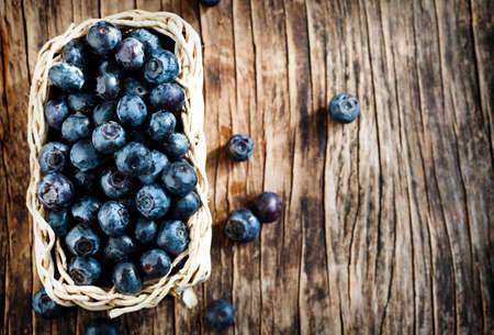 Fresh blueberries in basket on wooden backgroundの写真素材