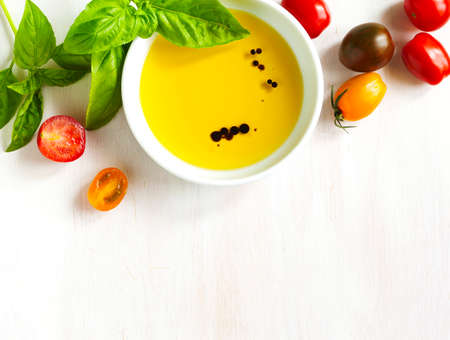 Fresh tomatoes, basil, olive oil with balsamic vinegar on wooden background, top viewの写真素材
