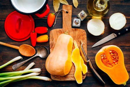 Preparing pumpkin, onions and sweet peppers for cookingの写真素材