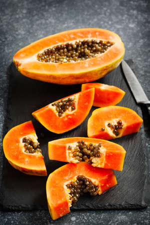 Fresh slices of sweet papaya on dark backgroundの写真素材