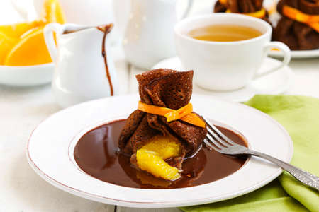 Chocolate pancakes with orange and chocolate sauceの写真素材