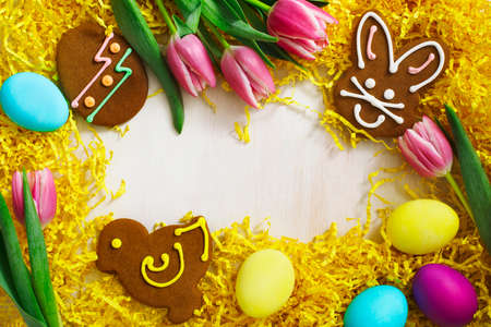 Easter background. Gingerbread in the form of colored Easter rabbit, chick and egg on white wooden backgroundの写真素材