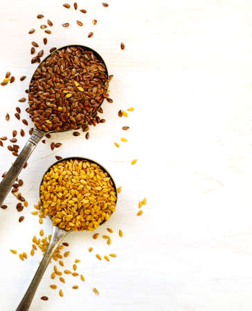 Brown and golden flax seeds in spoonsの写真素材