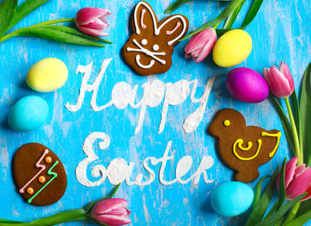 Easter eggs and Gingerbread in the form of colored Easter rabbit, chick and egg on wooden background. Happy Easter backgroundの写真素材