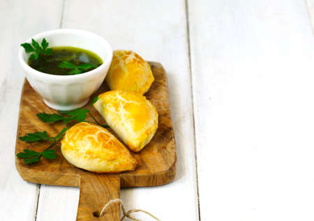 Empanadas with chimichurri sauce on wooden tableの写真素材