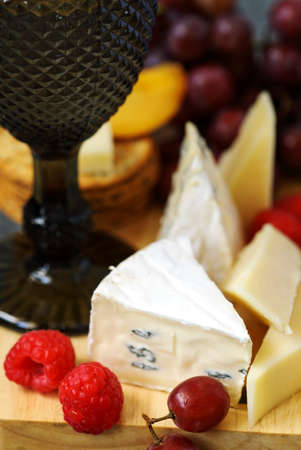 Cheese, creckers and fruits on wooden backgroundの写真素材