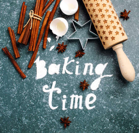 Baking time. Flour sprinkled on the blue table with text baking time. Baking ingredients.の写真素材