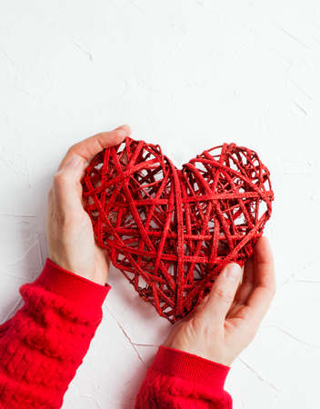 Female hands holding a red heartの写真素材
