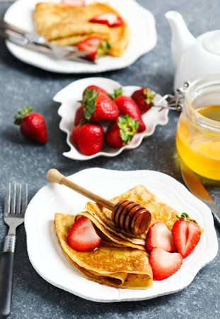Crepes with berries and honeyの写真素材