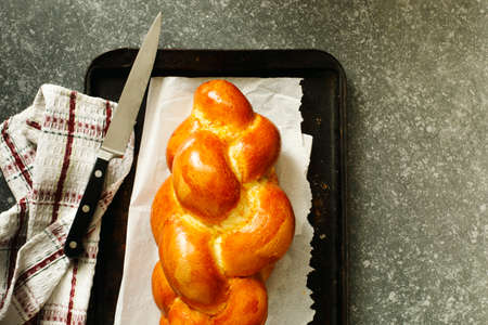 Freshly baked sweet braided bread loaf on a baking sheet.  Challah breadの写真素材